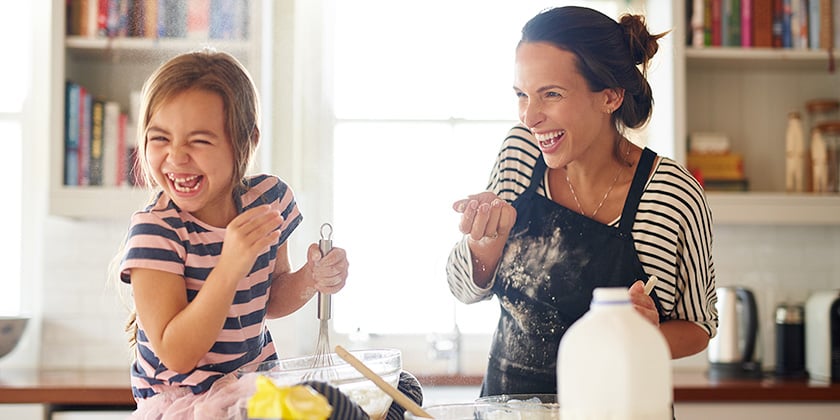 mother and daughter laughing together and baking