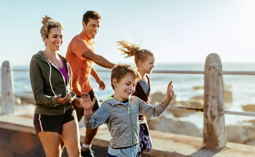 family running past a beach