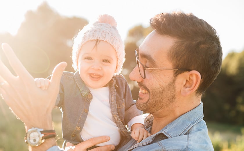 father wearing glasses holding son