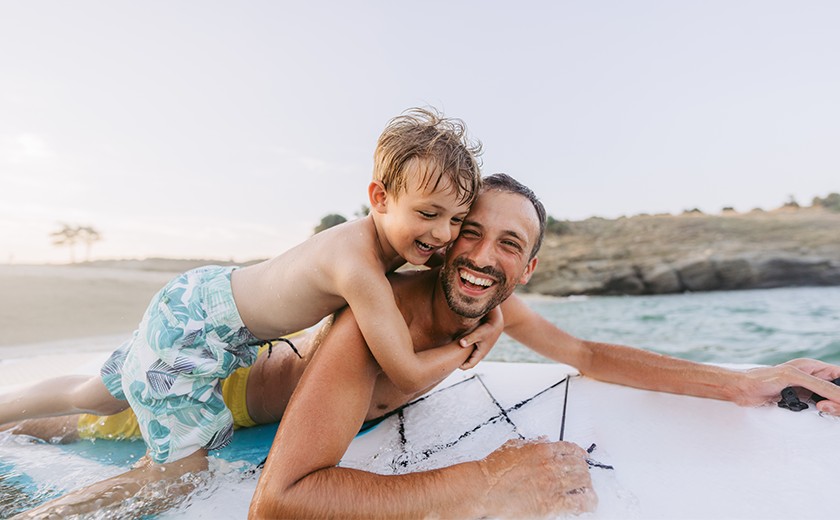 father and son playing by the water