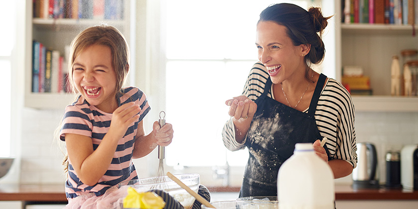 mother and daughter laughing together and baking